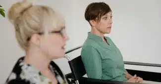 Femme en consultation médicale bienveillante, visage détourné, discussion avec professionnel de santé