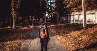 Femme d'âge mûr marchant à allure modérée sur un sentier naturel, posture détendue