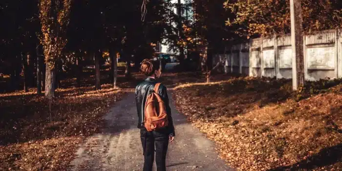 Femme d'âge mûr marchant à allure modérée sur un sentier naturel, posture détendue