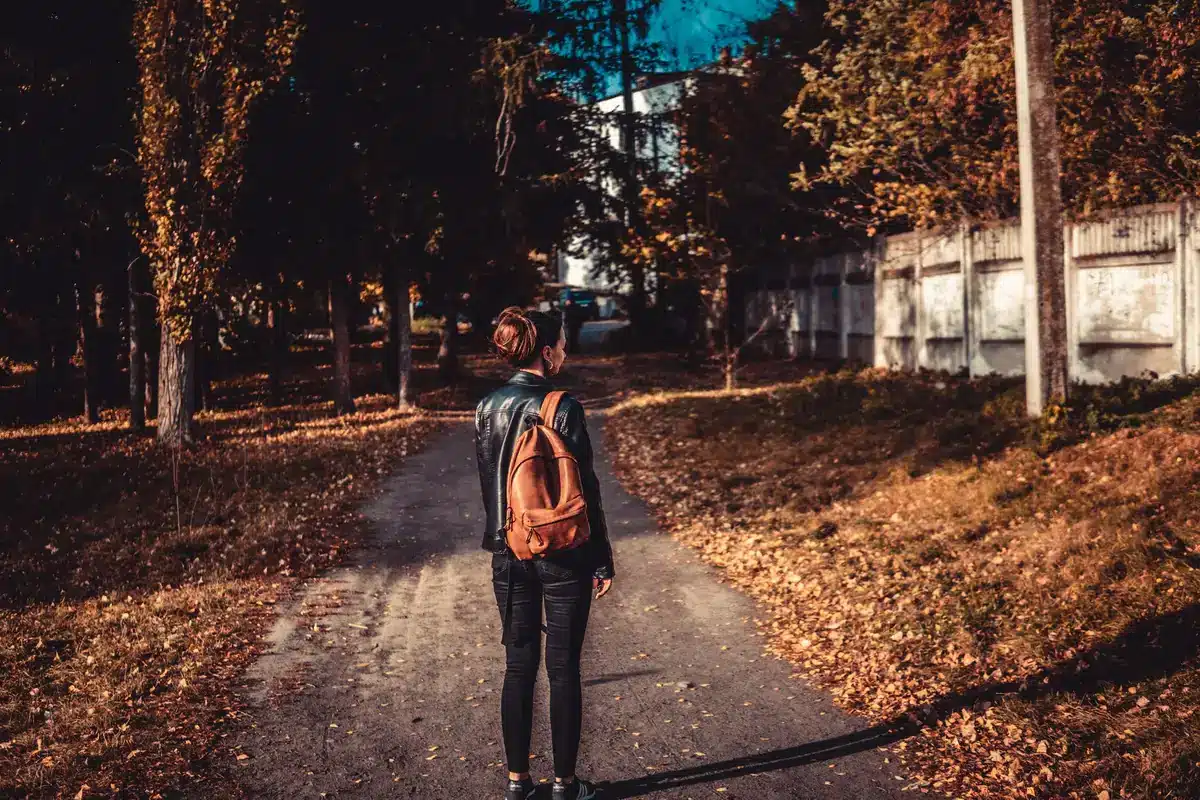 Femme d'âge mûr marchant à allure modérée sur un sentier naturel, posture détendue