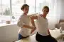 Mains d'un thérapeute effectuant un massage sportif sur l'épaule et le dos d'un athlète