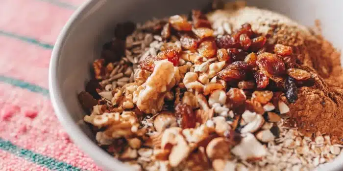 Bol d'overnight oats avec flocons d'avoine, fruits frais et noix sur un plan de travail