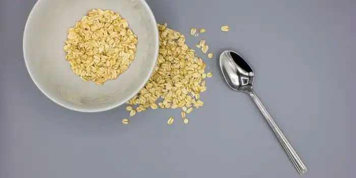 Bol de porridge aux flocons d'avoine épais et crémeux avec cuillère, sur un plan de travail de cuisine