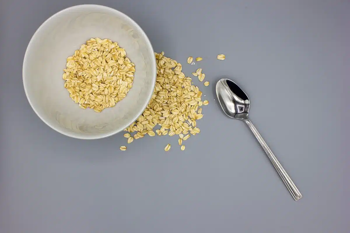 Bol de porridge aux flocons d'avoine épais et crémeux avec cuillère, sur un plan de travail de cuisine
