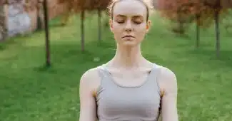 Personne assise en posture de détente, pratiquant une respiration contrôlée pour gérer l'anxiété