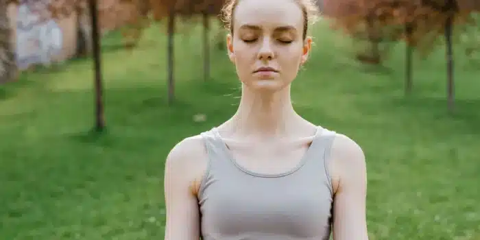 Personne assise en posture de détente, pratiquant une respiration contrôlée pour gérer l'anxiété