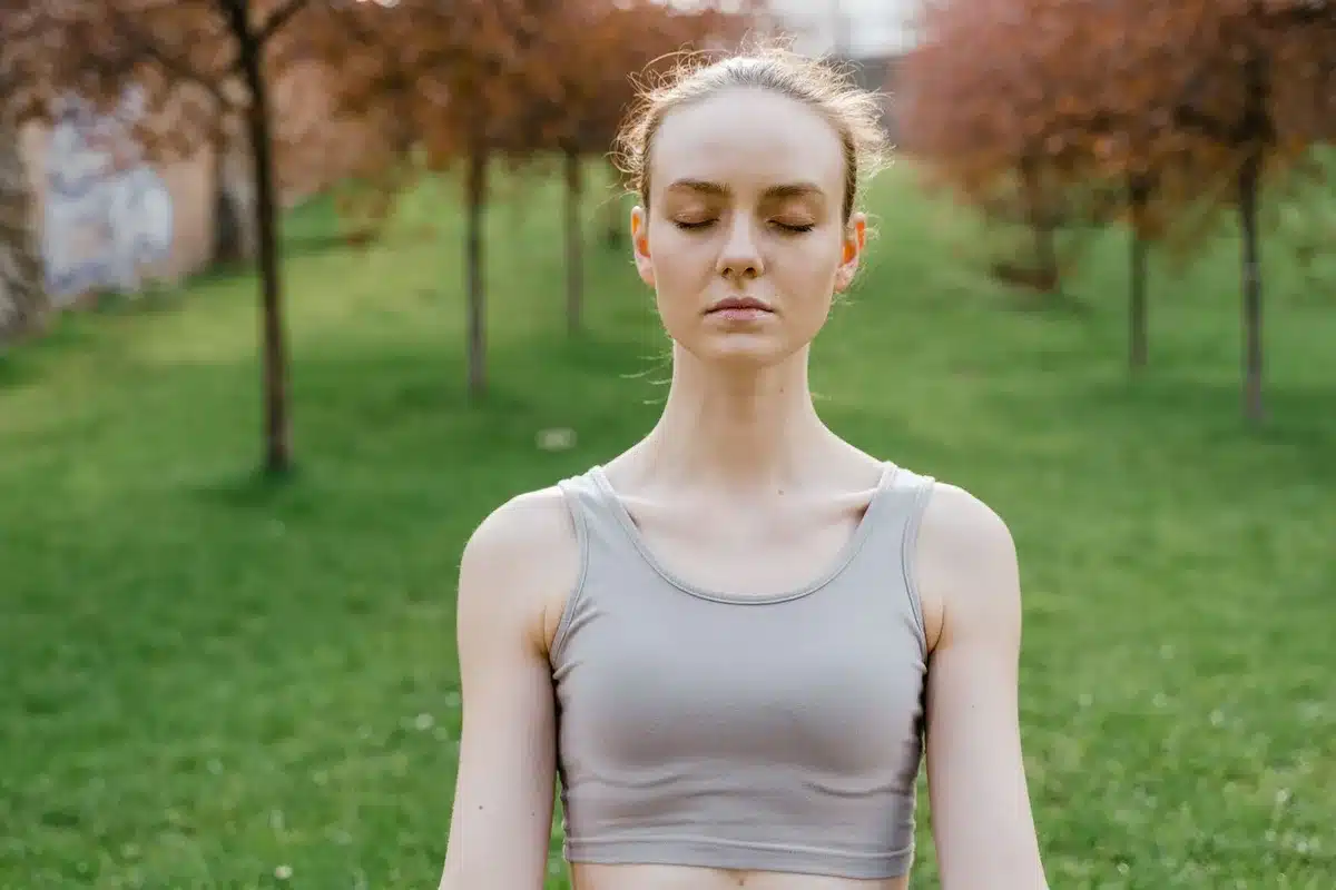 Personne assise en posture de détente, pratiquant une respiration contrôlée pour gérer l'anxiété