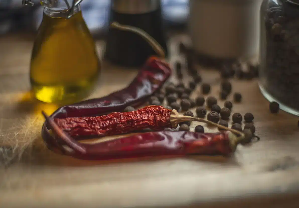 Ingrédients pour l'huile pimentée maison : huile d'olive, piments séchés, romarin et thym