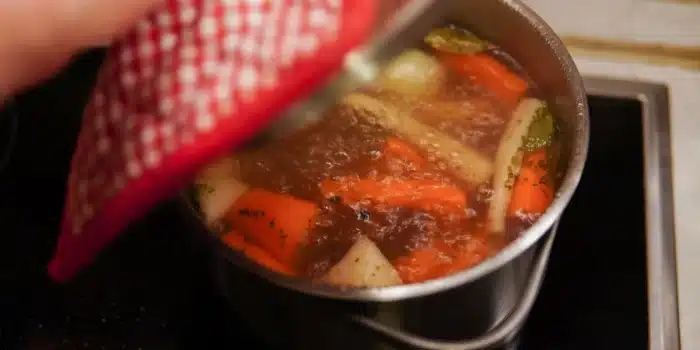 Légumes racines frais et herbes aromatiques sur un plan de travail rustique, prêts à la préparation culinaire.