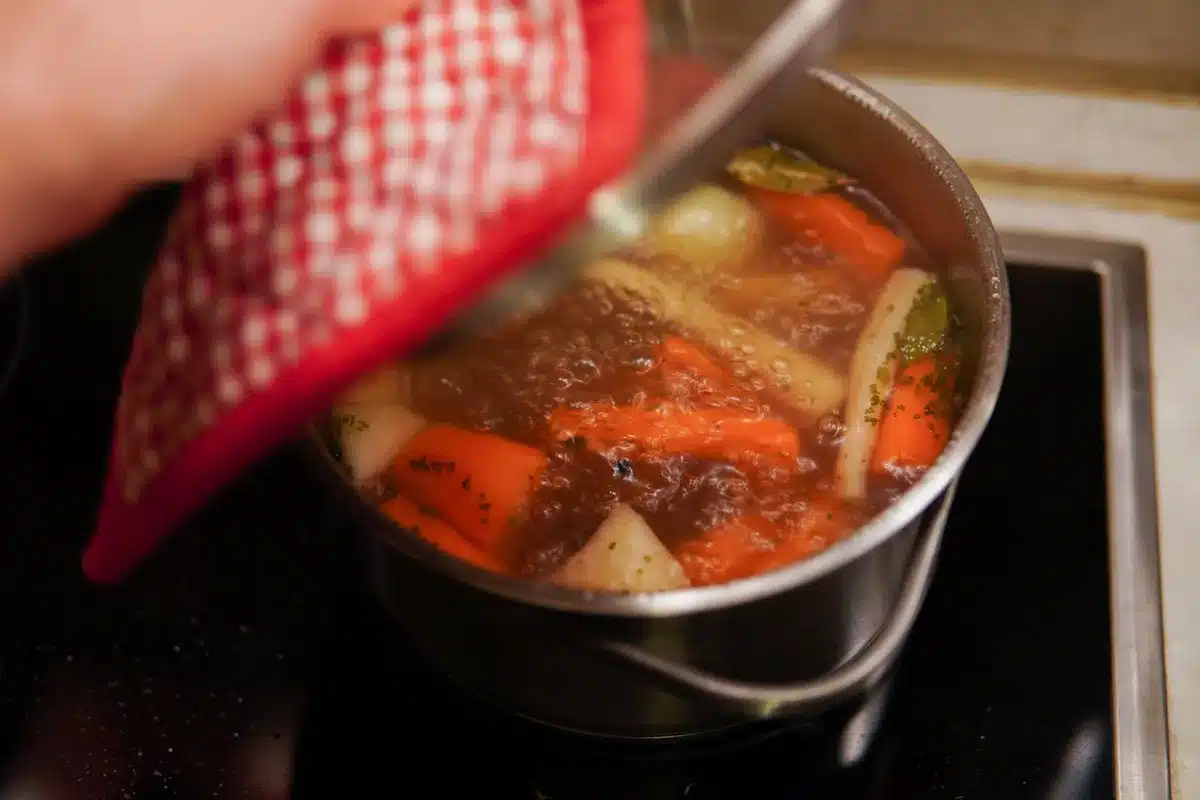 Légumes racines frais et herbes aromatiques sur un plan de travail rustique, prêts à la préparation culinaire.