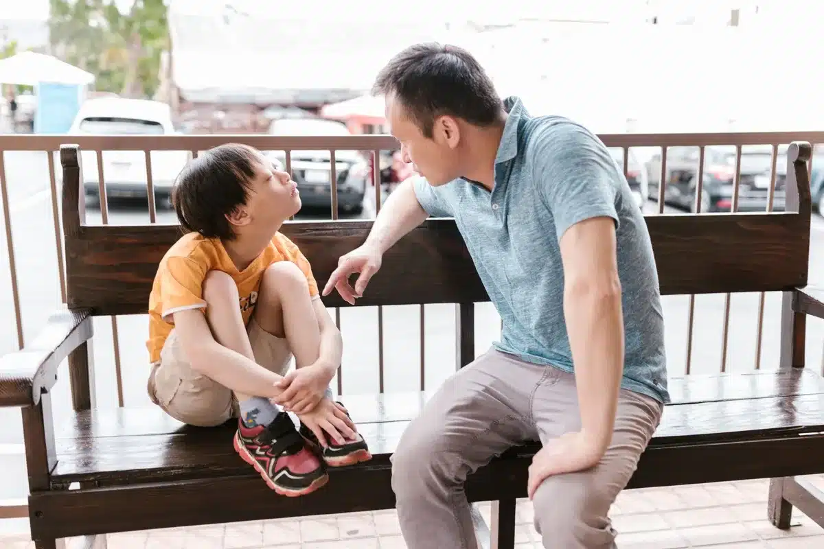 Deux personnes en conversation bienveillante, illustrant le soutien émotionnel et la communication ouverte en famille.