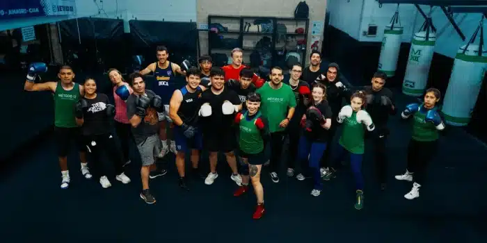 Groupe de personnes en tenue de sport pratiquant une activité collective dans un gymnase, symbolisant l'insertion par le