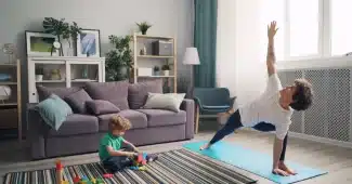 Maman faisant du sport à domicile avec son enfant qui joue à proximité