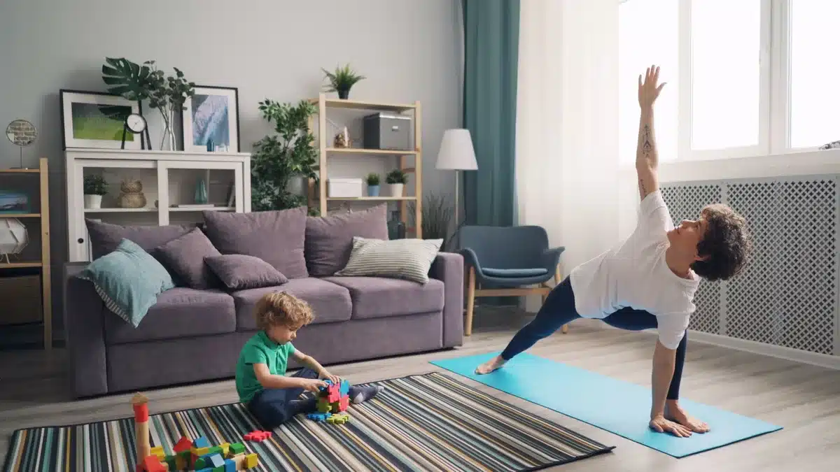 Maman faisant du sport à domicile avec son enfant qui joue à proximité