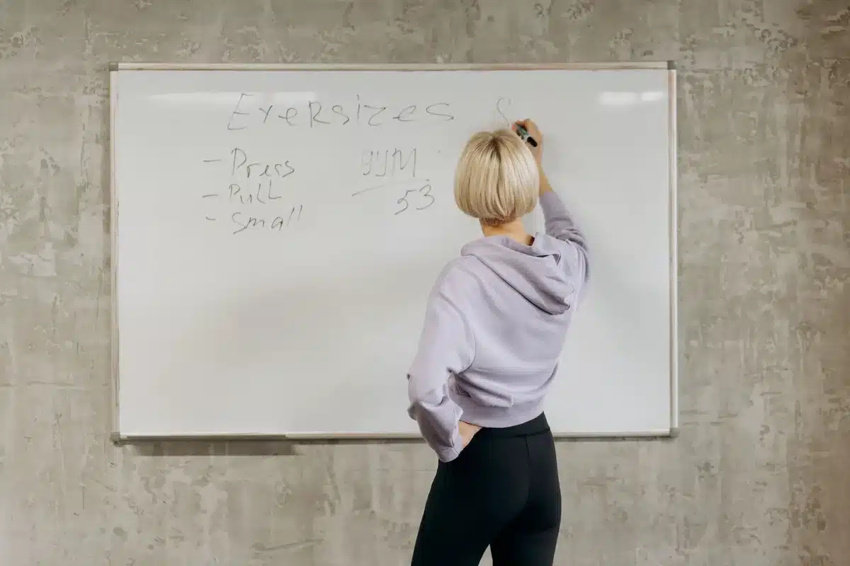 Coach animant une séance devant des adhérents en salle de fitness