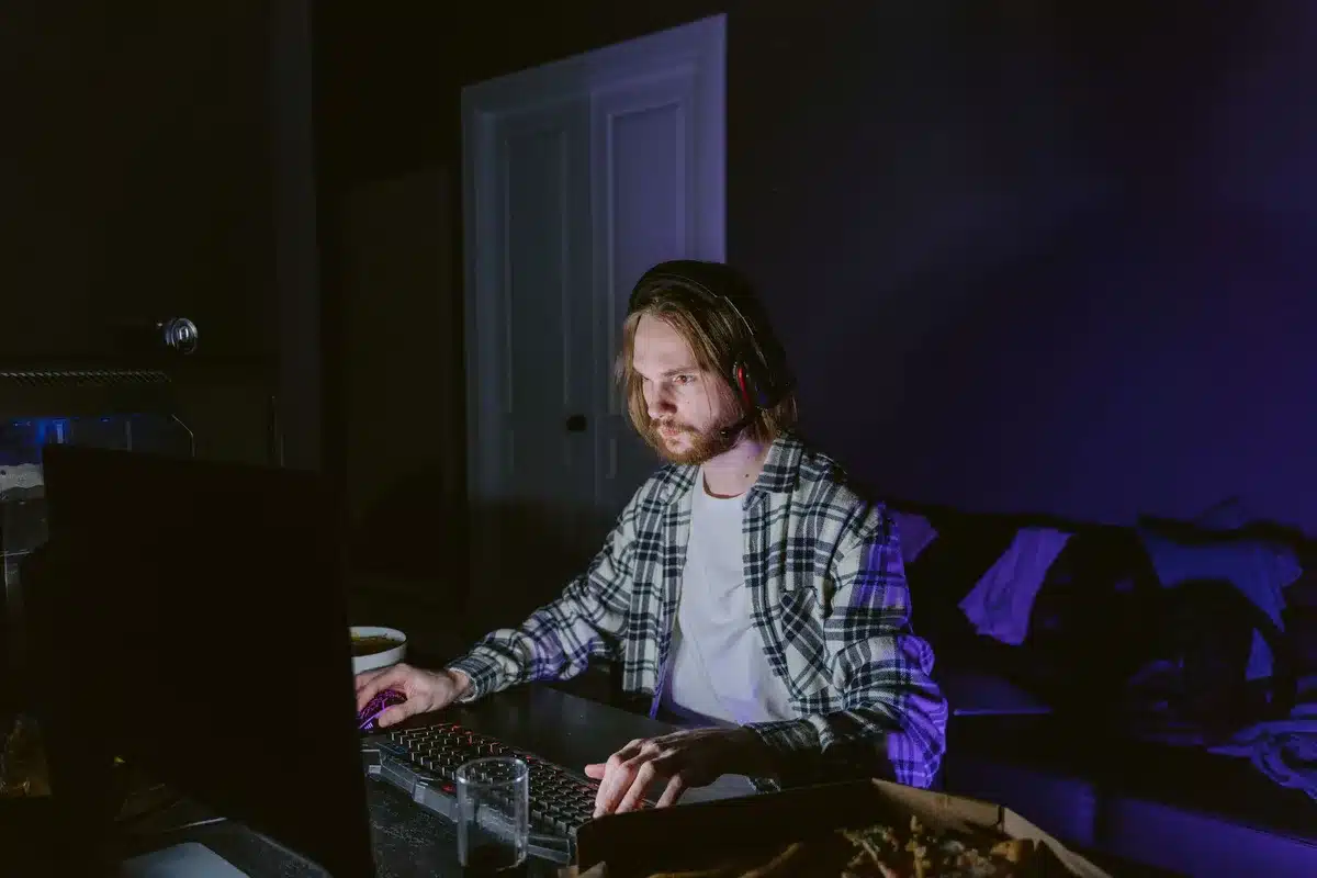 Un adolescent devant un écran de jeu, immergé dans le gameplay