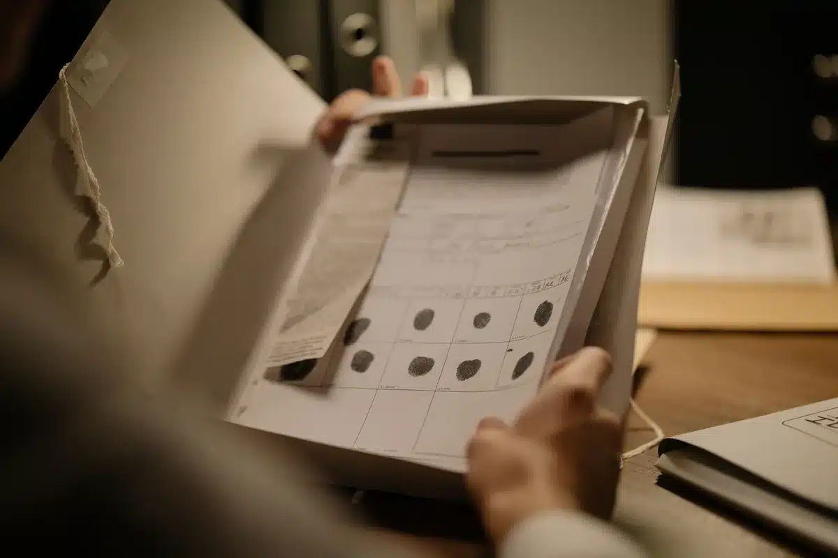 Mains tenant un carnet avec des captures d'écran et des notes de dates pour documenter un harcèlement