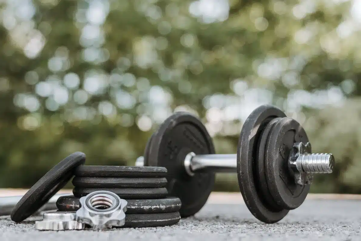 Une personne effectuant un exercice de renforcement musculaire avec des poids légers en salle de sport