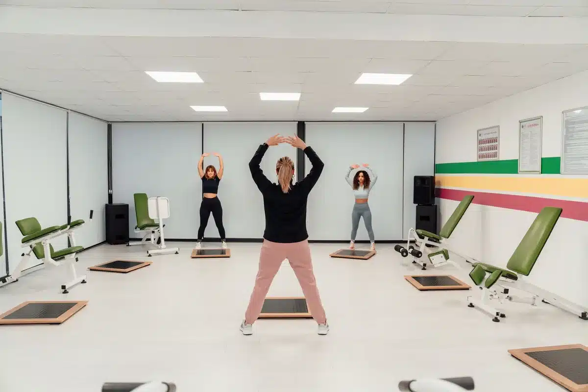 Un cours collectif en salle de sport avec plusieurs participants et un coach