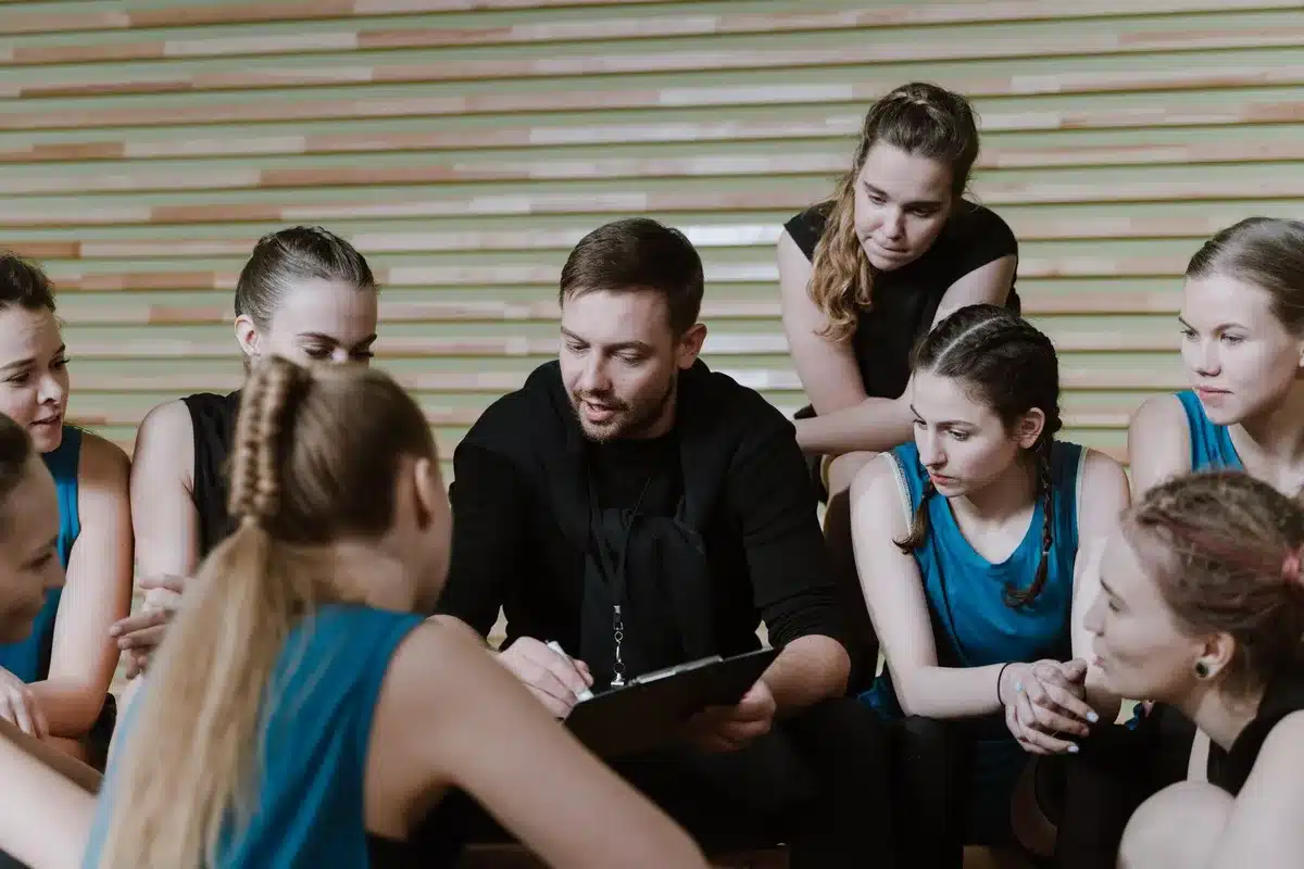 Une équipe de coachs et d'adhérents dans une salle de sport, échangeant et s'écoutant