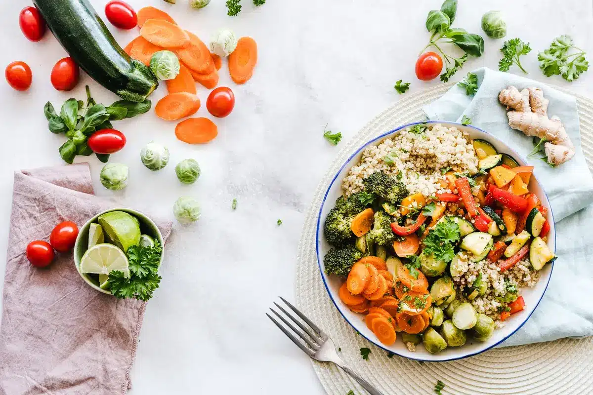 Assortiment de légumes frais coupés : concombre, tomate, courgette et pastèque sur une assiette.