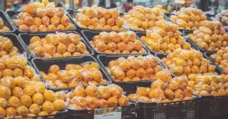 Mains anonymes comparant les étiquettes nutritionnelles de deux produits alimentaires en rayon de supermarché