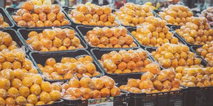 Mains anonymes comparant les étiquettes nutritionnelles de deux produits alimentaires en rayon de supermarché