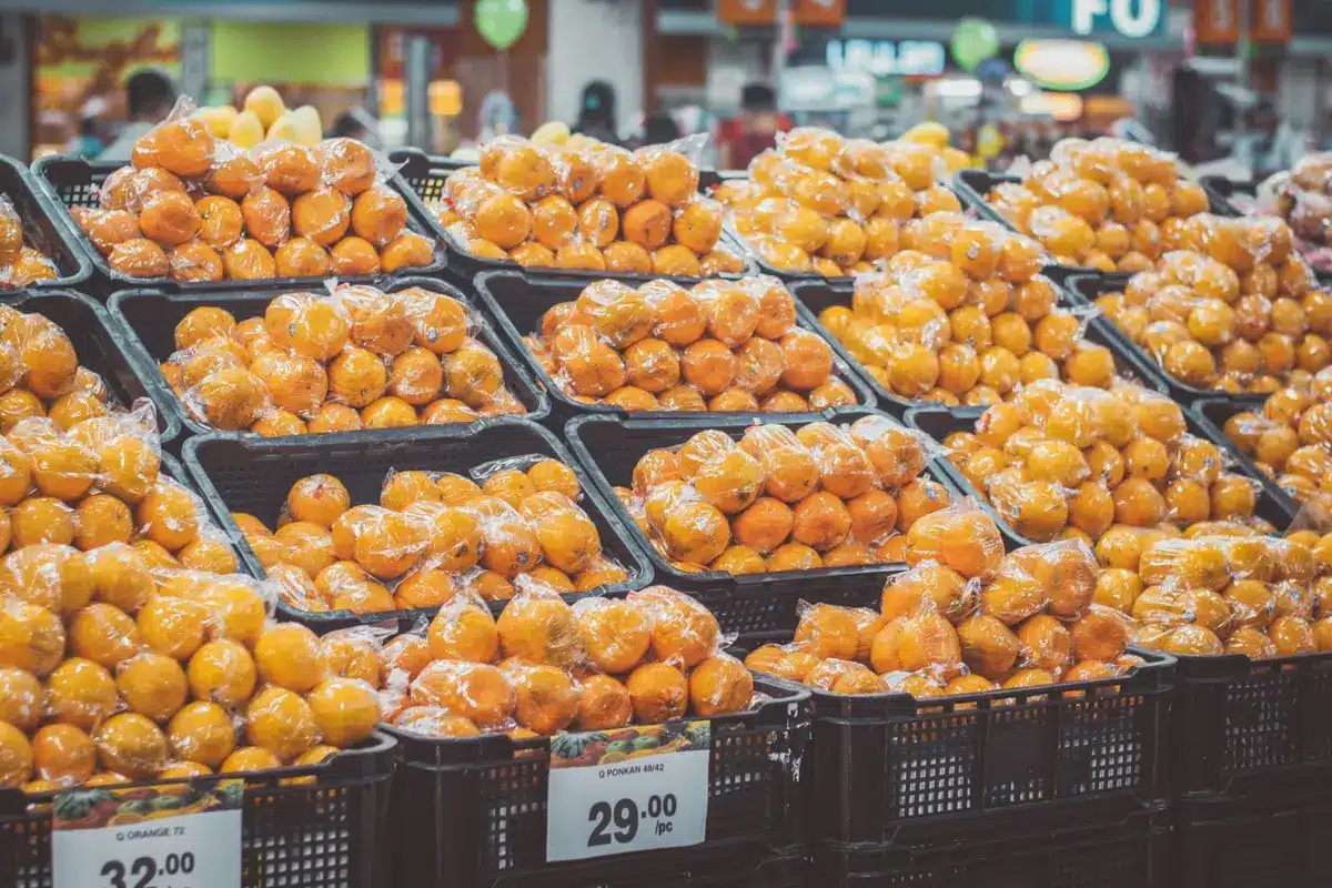 Mains anonymes comparant les étiquettes nutritionnelles de deux produits alimentaires en rayon de supermarché