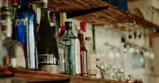 Main d'une personne atteignant une bouteille sur un rayon de magasin, symbolisant le choix du consommateur sans informat