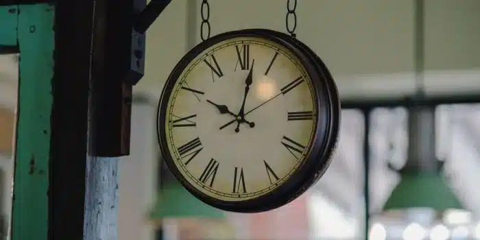 Assiette de déjeuner avec horloge en arrière-plan, illustrant l'importance du timing des repas.