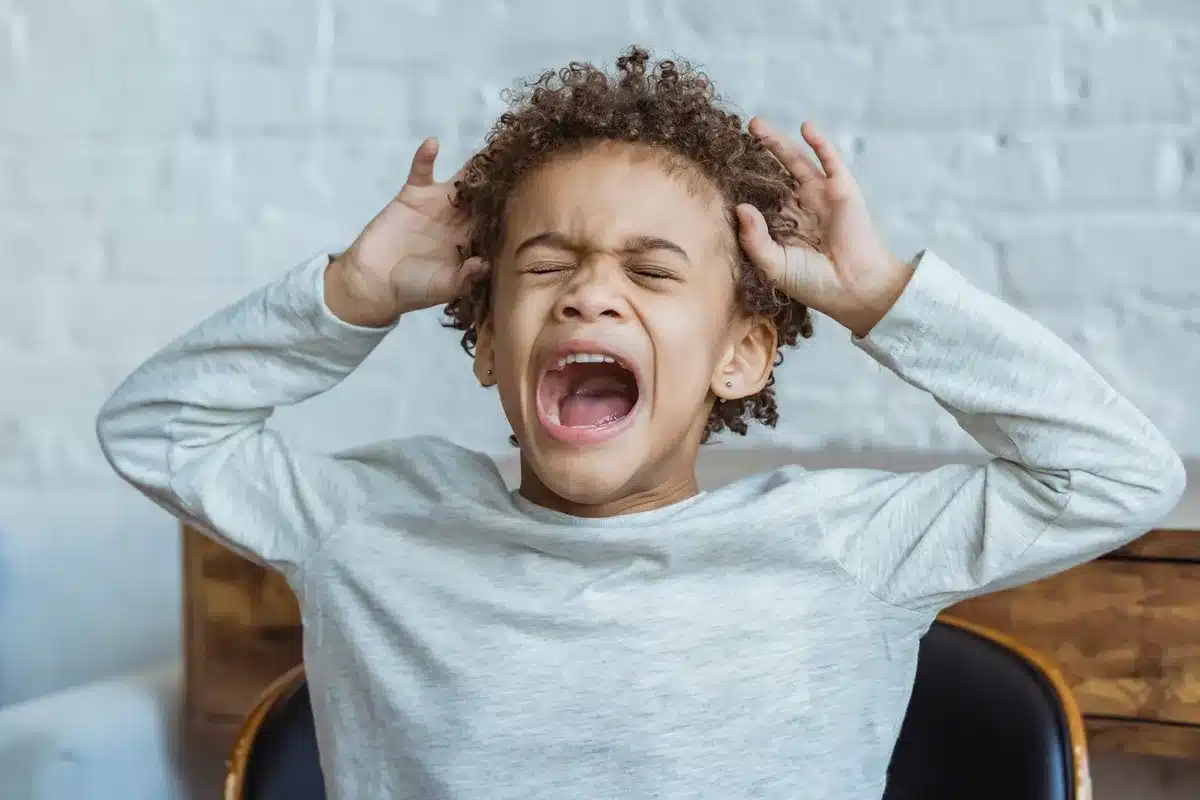 Enfant montrant des signes de surcharge sensorielle et de fatigue émotionnelle.