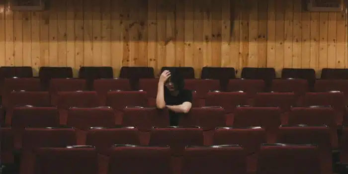 Personne assise seule, semblant fatiguée, dans un environnement calme et lumineux
