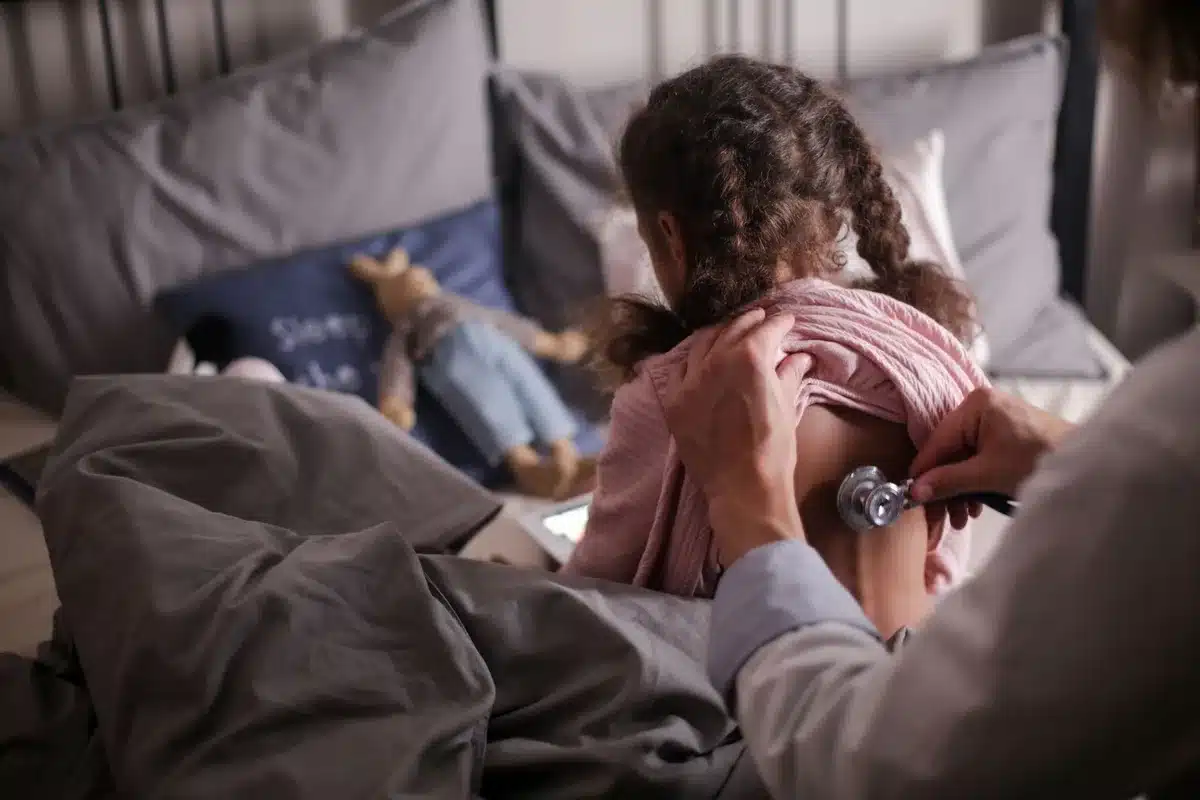 Pédiatre examinant un enfant lors d'une consultation médicale.