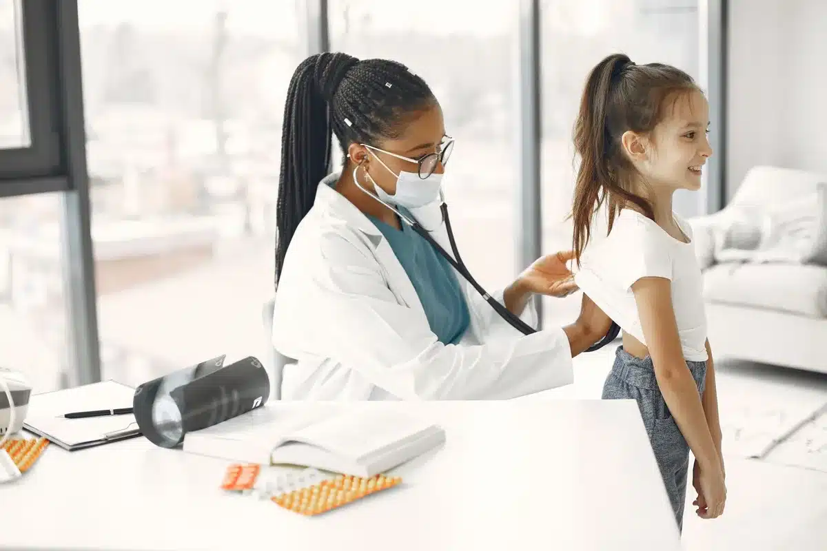 Enfant mesuré contre un toise dans un cabinet médical pour vérifier la croissance.