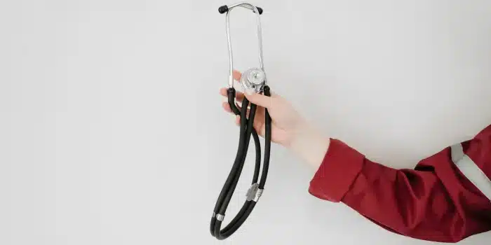Main tremblante d'une personne pendant une urgence médicale avec une horloge en arrière-plan