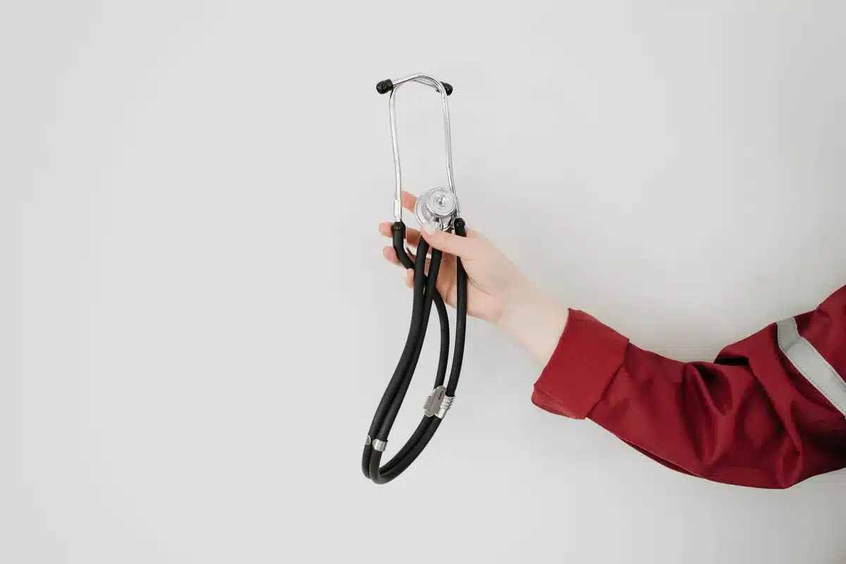 Main tremblante d'une personne pendant une urgence médicale avec une horloge en arrière-plan
