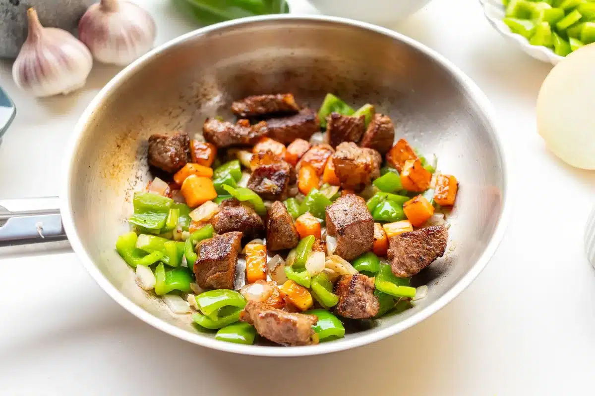 Légumes en train de cuire à la poêle avec oignon et ail