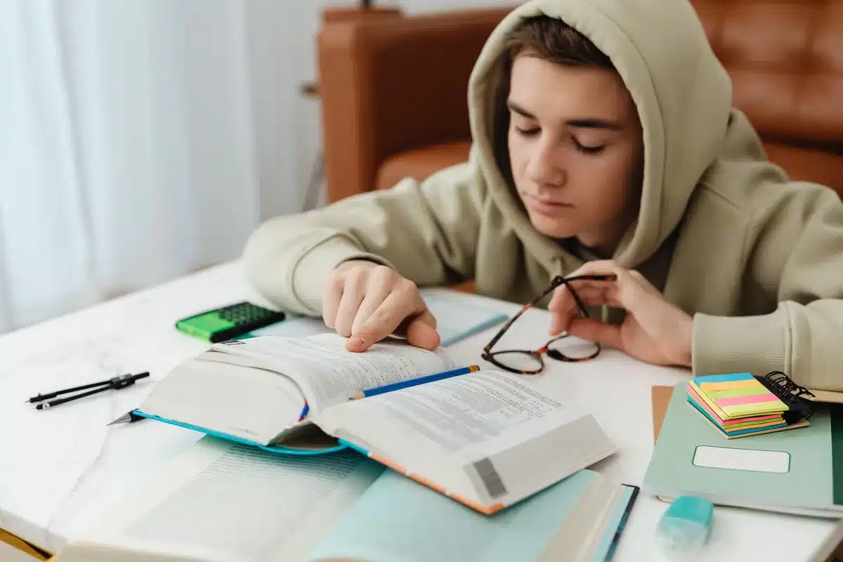 Adolescent plongé dans la lecture, concentré sur les mots et le rythme du texte