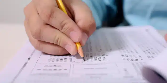 Mains anonymes remplissant un questionnaire médical sur un bureau clair avec un stéthoscope