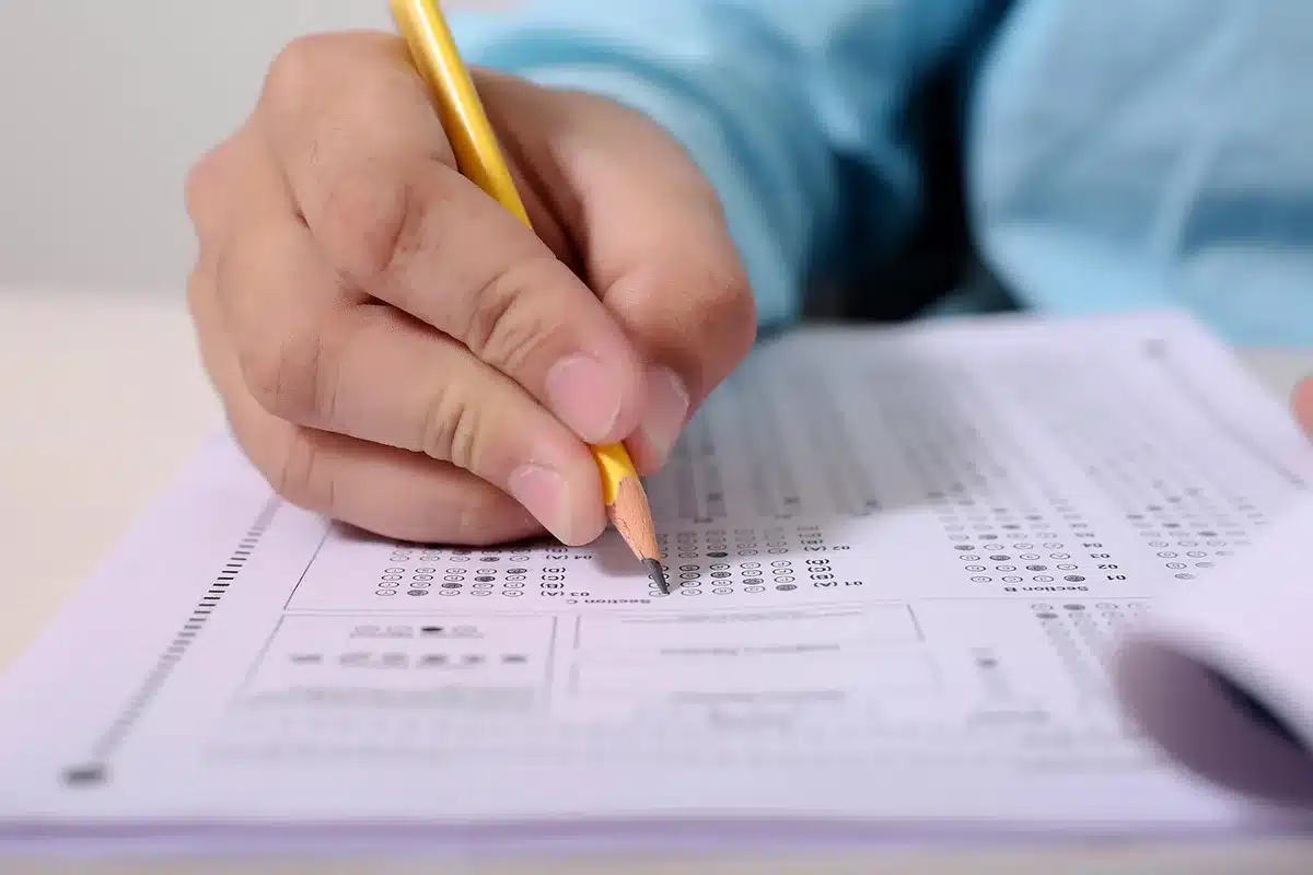 Mains anonymes remplissant un questionnaire médical sur un bureau clair avec un stéthoscope