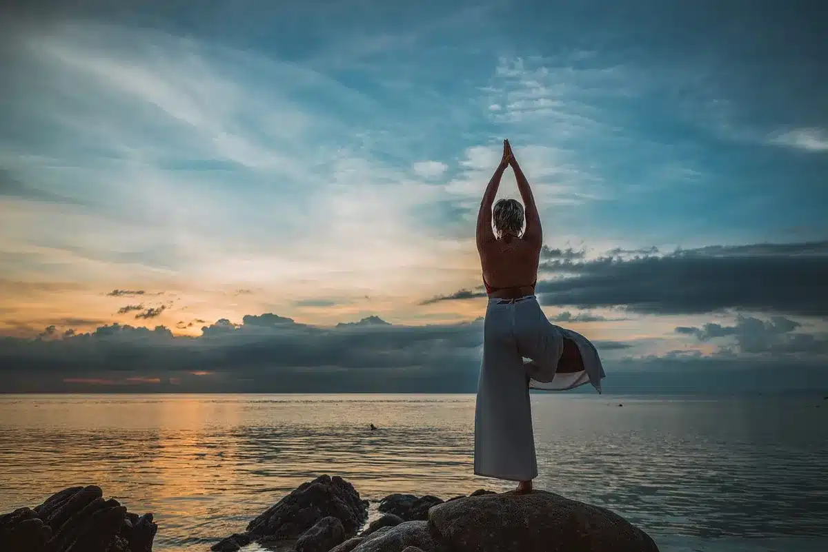 Tapis de yoga près d'une fenêtre avec écouteurs, ambiance calme