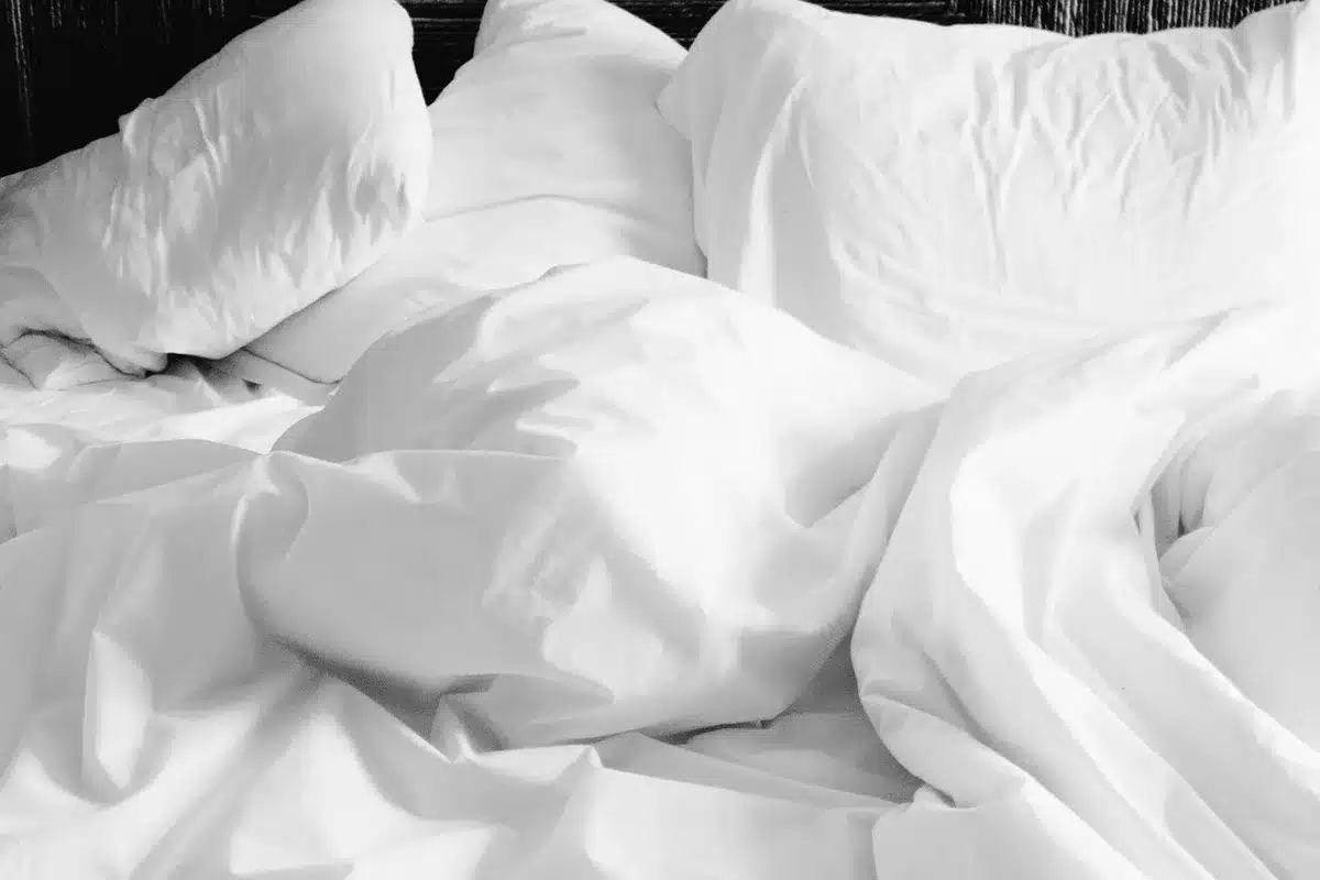 Personne dormant paisiblement sur le lit dans une chambre sombre