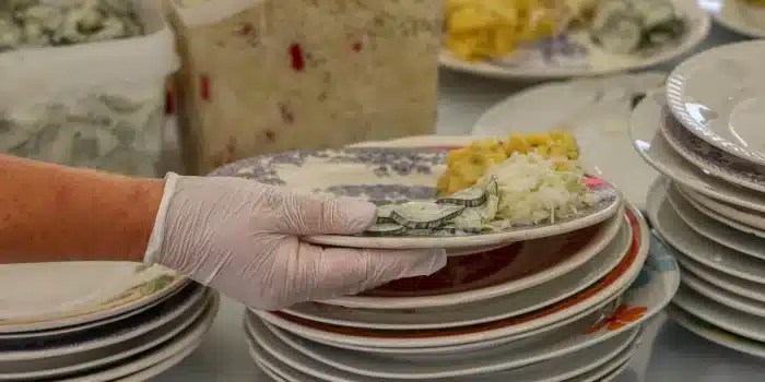 Concombres non identifiables sur un étal, mains vérifiant la fermeté