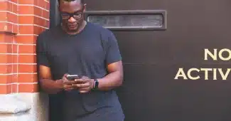 Main tenant un téléphone avec notifications et applications visibles à l'écran