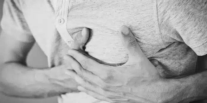 Personne effectuant un auto-massage doux de son genou dans un environnement calme et bien éclairé