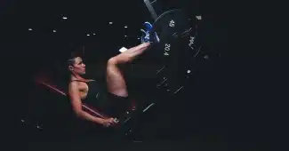 Coin de salle de sport avec barre, kettlebell et silhouette floue en arrière‑plan