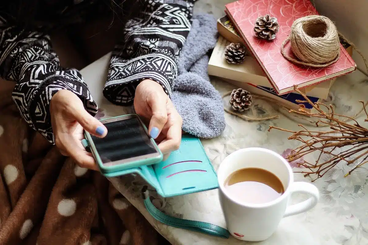 Personne seule sur un canapé regardant son téléphone à la lumière du jour