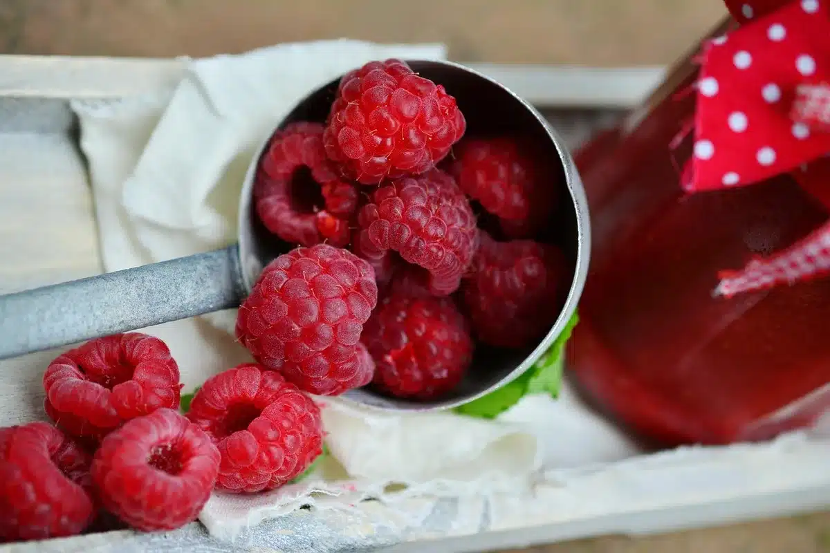 Bananes et framboises dans un bol sur une table en lumière du jour