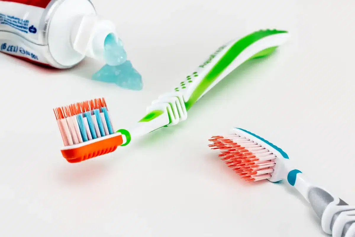 Enfant se brossant les dents avec un adulte supervisant