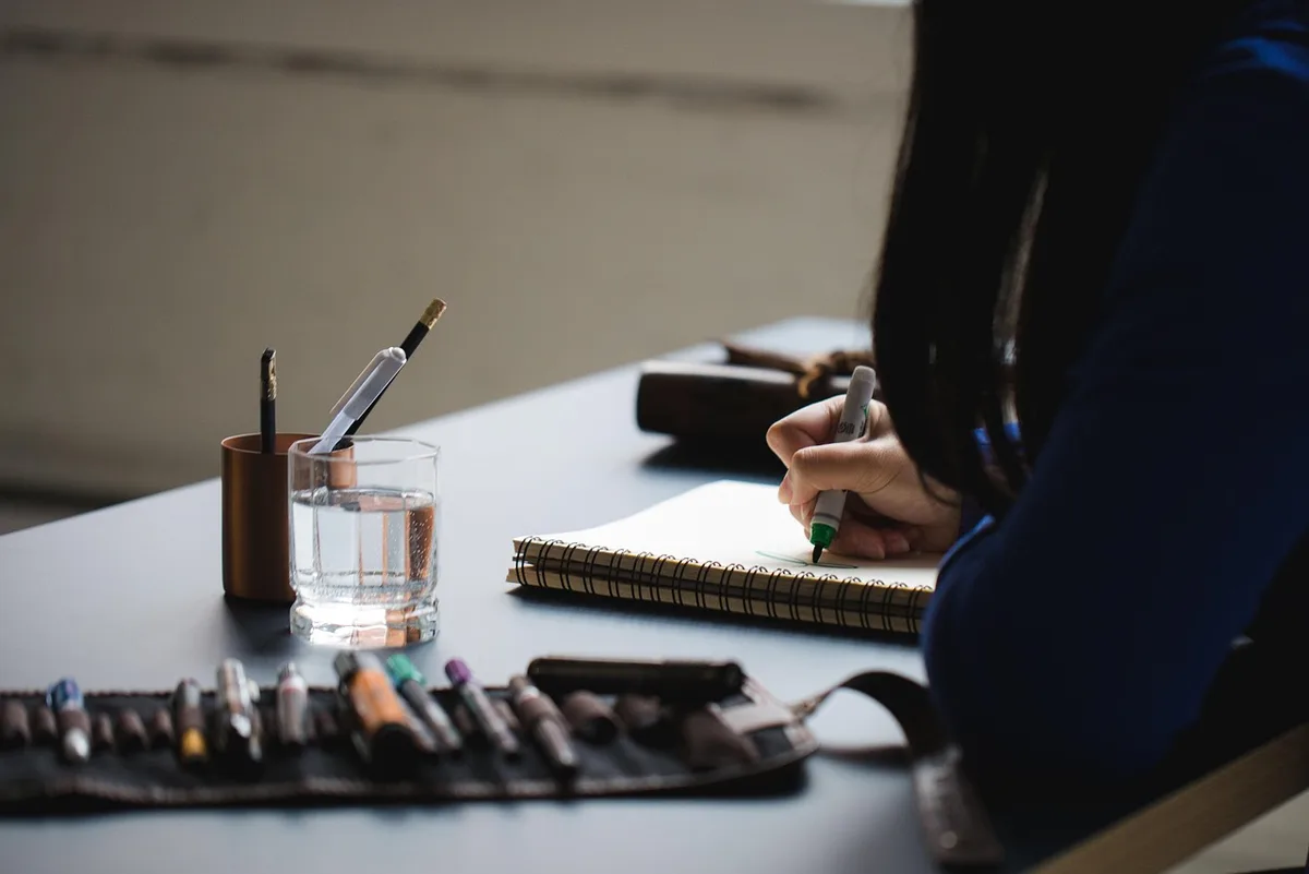 Carnet, minuteur et post‑it sur une table ensoleillée pour une session créative